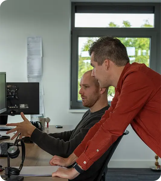 Twee developers van KJ Software kijken samen naar een scherm